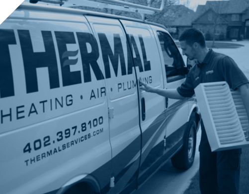 an HVAC tech is putting equipment in a thermal heating air and plumbing truck in Omaha NE